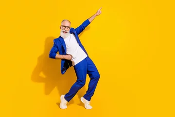 Keuken spatwand met foto Full size photo of grey haired funky old grandfather point finger disco dance smile isolated on yellow color background © deagreez