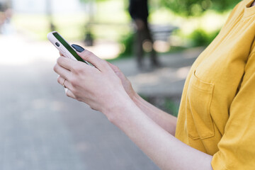 Close up female hands holding a smartphone. Typing a message