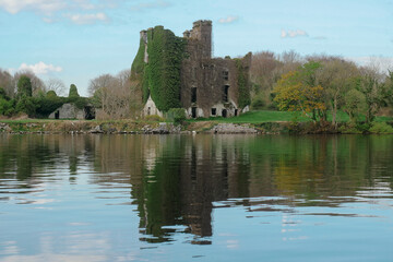 Fototapeta na wymiar Ruins of Menlo castle covered with ivy on river Corrib, Galway city, Ireland. Building reflection in water. Nobody. Historical landmark.