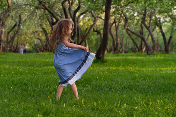 Naklejka premium little girl runs barefoot on the grass. happy child on a hot summer day.