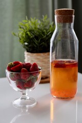 juice in a glass and strawberry in the table with flowers