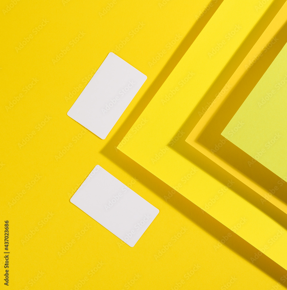 Poster blank white rectangular business card on creative yellow background from sheets of paper with shadow