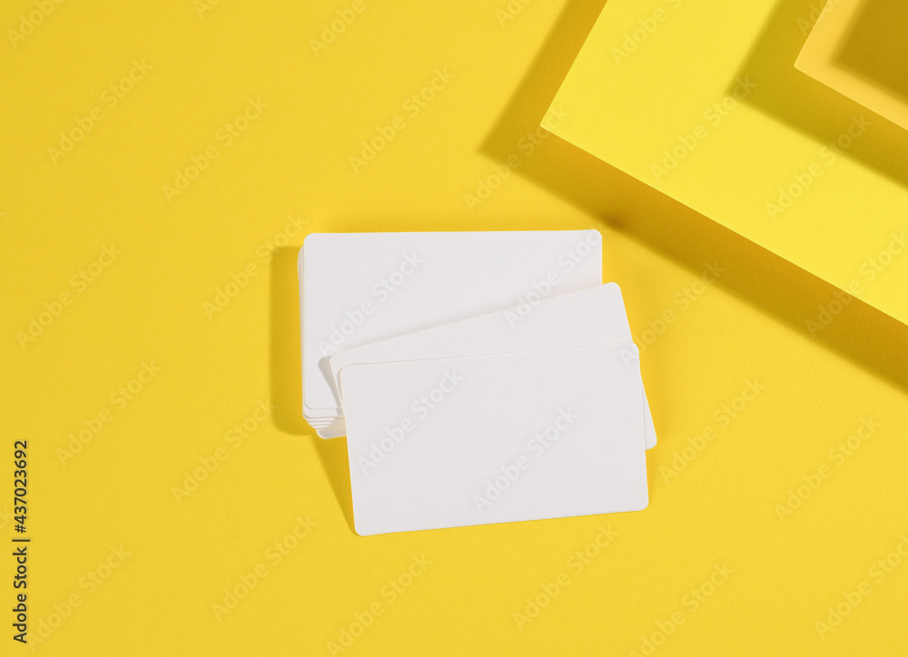 Poster blank white rectangular business card on creative yellow background from sheets of paper with shadow
