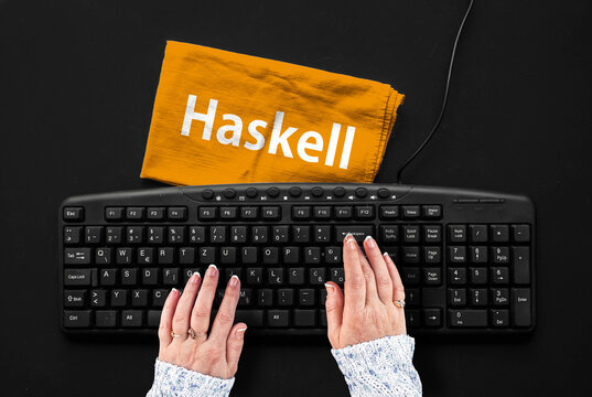Haskell programming language. Rag width word Haskell and hands on pc keyboard
