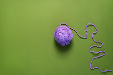 Purple Yarn Ball Thread on green Background.