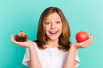Photo portrait girl scaling sweet cupcake apple smiling happy isolated bright teal color background