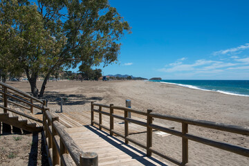 Fototapeta na wymiar Ramp with a wooden railing, which goes down to the lonely beach of Bolnuevo. Mazarron, Murcia, Spain