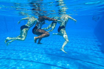 Synchronized Swimming Girls Team Unrecognizable Dance Underwater photography closeup action in blue...