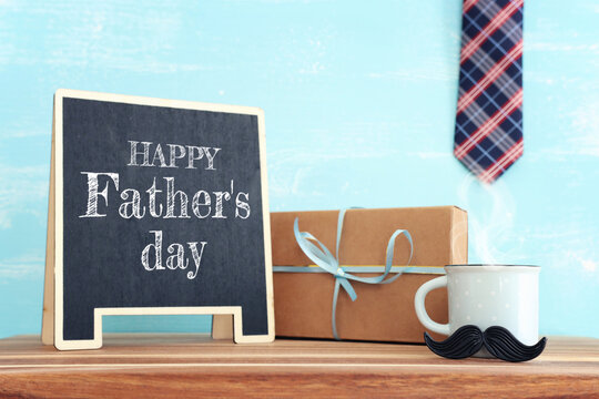 image of fathers day composition with hot cup of coffee and blackboard over table