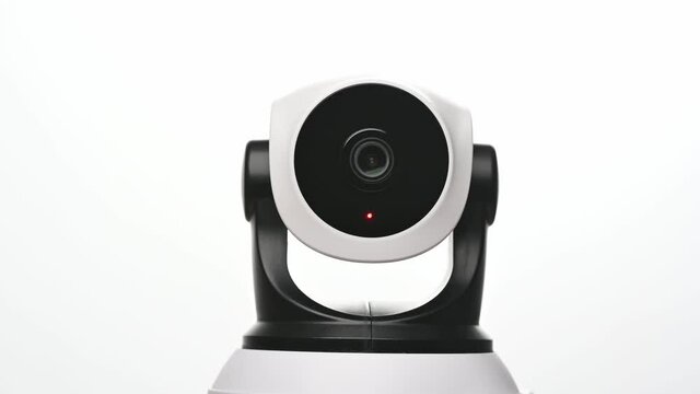 Surveillance IP Internet CCTV camera system remotely operated. Smartphone controlled home security camera moving filming around in 4k footage isolated on white background.
