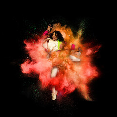 Young sportsman, female female dancer in action in explosion of colored powder explosion isolated...