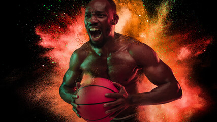 Fototapeta na wymiar One young African sportsman basketball player in explosion of colored neon powder isolated on black background