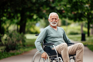 Obraz premium Senior disabled man, posing for the camera, in his wheelchair.