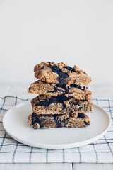 Stack of freshly baked oat blueberry scones on white plate, close up. Sweet food with natural ingredients. Vegan gluten free pastry.