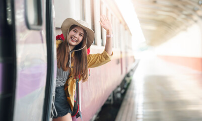 Fototapeta premium Beautiful traveler waving hand while getting on the train.