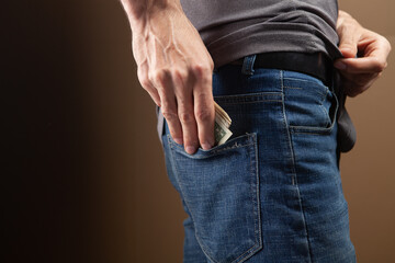 man puts money in his back pocket