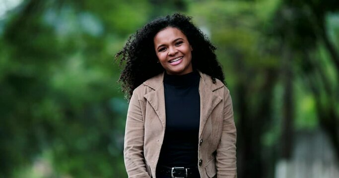Positive joyful African ethnicity girl portrait, young millennial elegant woman outside at park