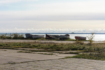 Boats on the shore. Fishing boats on land in the evening. Fishing boats near the pond.