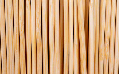 Multiple wooden bamboo skewers laying on white background macro