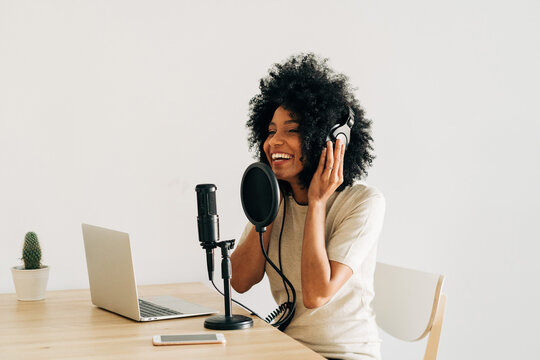 Positive young African American woman talking at online radio station