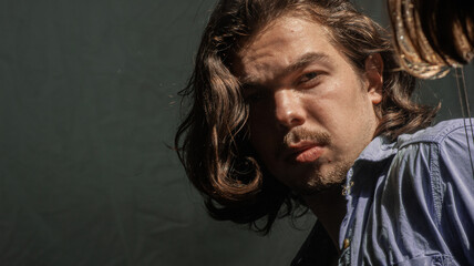 Obraz premium The man is watching himself in the mirror with his attractive gaze. She has a sexy stance with her long blonde hair and a blue shirt.