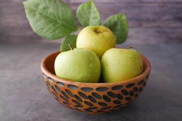 Close up of fresh apple in a bowl on wooden table 