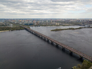 Fototapeta na wymiar Automobile bridge across the Dnieper river in Kiev. Aerial drone view.