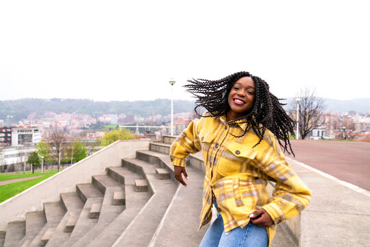 Energetic black woman dancing on concrete border
