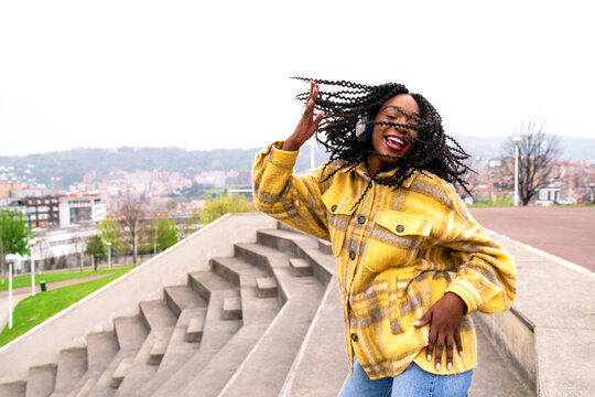 Energetic black woman dancing on concrete border