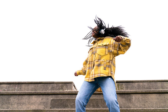 Energetic black woman dancing on concrete border