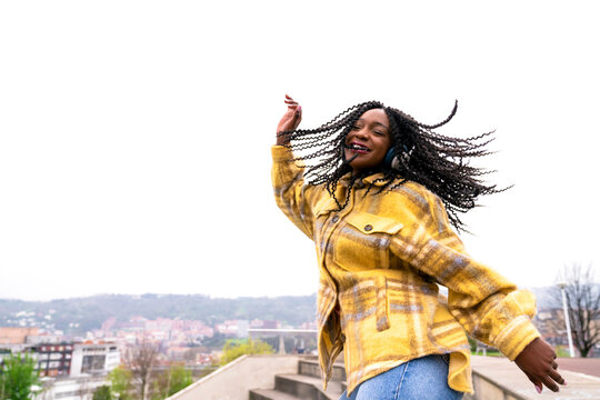 Energetic black woman dancing on concrete border
