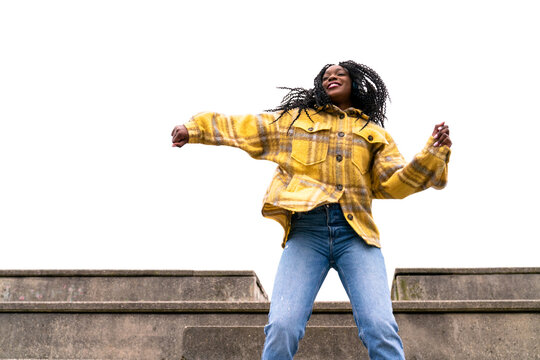 Energetic black woman dancing on concrete border
