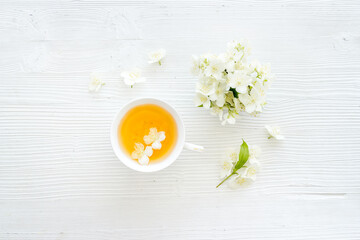 Jasmine flowers with green tea in a cup. Overhead view