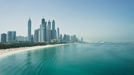 Travel, tourism, cityscape, finance or business concept. Fastest growing city in the world. Dubai city skyline with skyscrapers, sea and beach. United Arab Emirates. High quality image