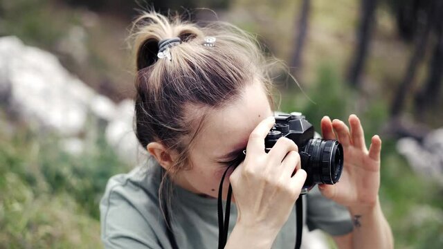 Slim professional caucasian woman photographing nature on in the natural park