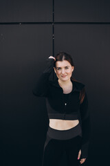 sport, fitness and people concept - young woman in black sportswear posing in gym