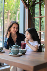 Mom and daughter relax in a cafe.