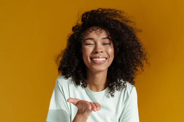 Young african woman laughing while holding copyspace