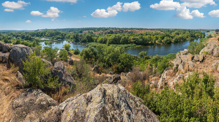 Fototapeta na wymiar Summer Pivdennyi Buh (Southern Bug) river in Myhiya, Mykolayiv Region, Ukraine. Landscape of the river with rocky coast.