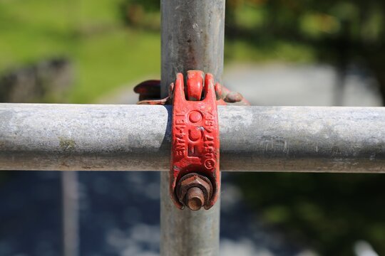 A close up view of a metal joint on a piece of scaffolding pipe.