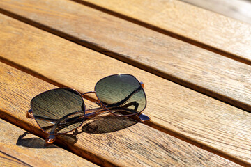Fototapeta na wymiar Trendy fashionable sunglasses on wooden table
