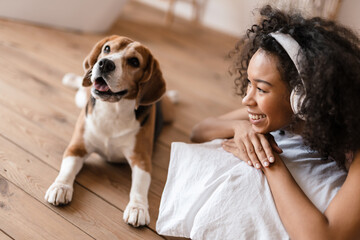 Young african woman in casual wear with beagle puppy
