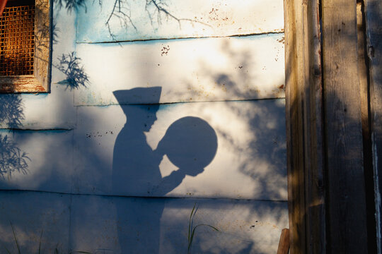Shadow of a boy in a Soviet cap, a child holding a round globe