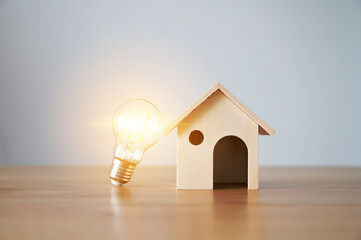 Light bulb and wooden house on the table. Concept of inspiration creative idea thinking and future...