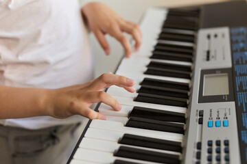 Fototapeta na wymiar Selective focus of kid's fingers playing the piano.