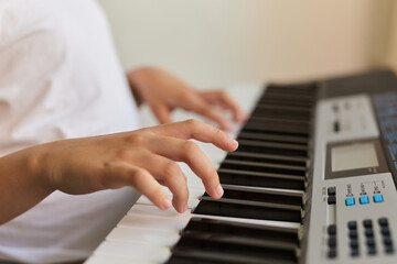Obraz premium Selective focus of kid's fingers playing the piano.