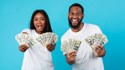 Excited African American couple holding a lot of dollar money