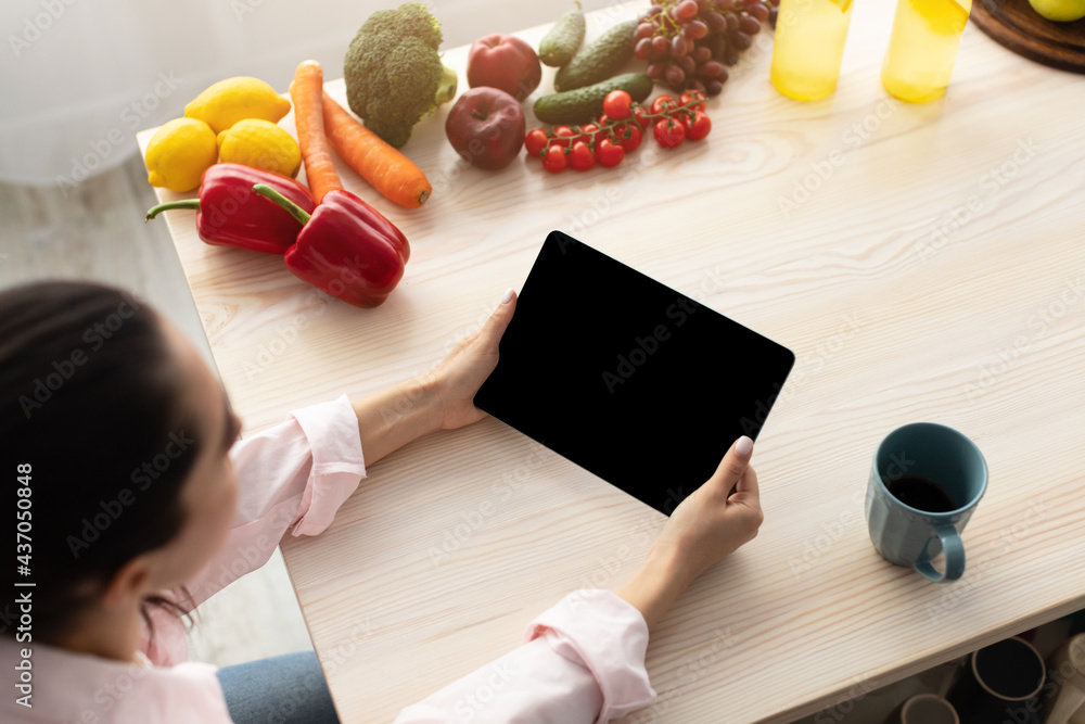 Poster Woman using tablet with empty screen for mockup in morning