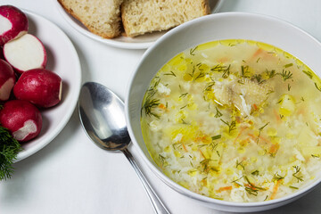 Homemade rice soup on a white tablecloth. Nutritious lunch. Healthy nutrition concept
