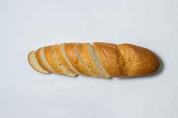 Sliced baguette on a white tablecloth. Bakery product. Delicious bread